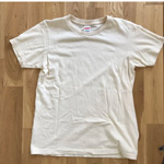 床の上に置いたオフホワイトのユナイテッドアスレの半袖Tシャツの写真