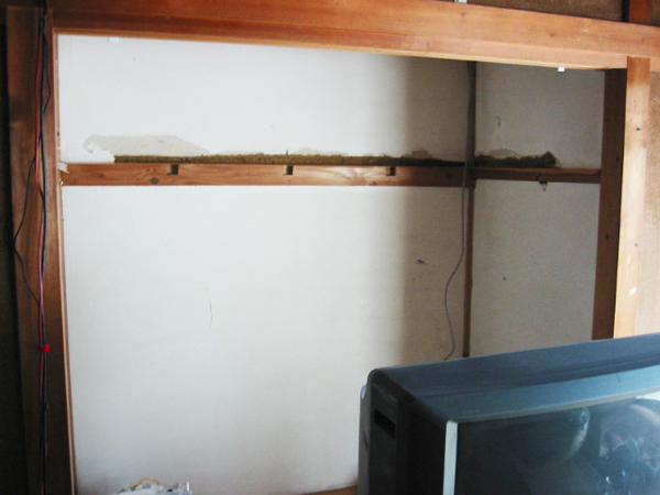 押入れの棚板を撤去後に土壁を補修している様子
