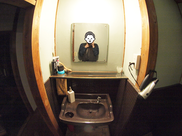 茶色に塗装された洗面スペースとペールグリーンの壁