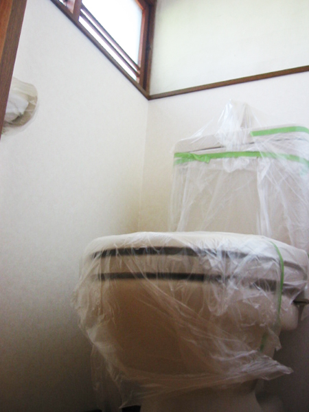 ペンキで塗装する前にトイレを養生する様子
