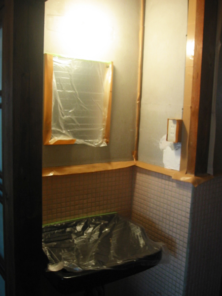 洗面所の壁を塗装するのに養生する様子