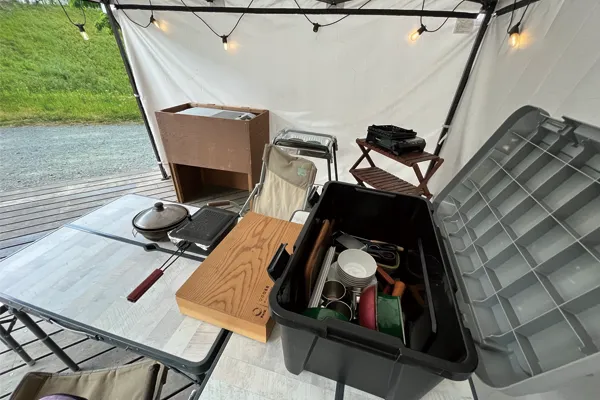 タープテントの中にキャンプで使う料理セットが置かれている様子