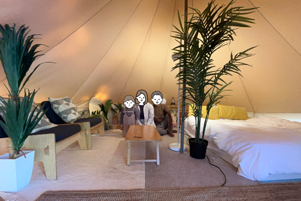 天井の高いテントの中で記念写真を撮る家族