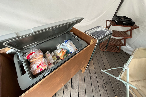 クーラーボックスの中に食パンやビールに食材が入っている様子