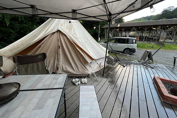テントサイトのデッキが雨で塗れる様子