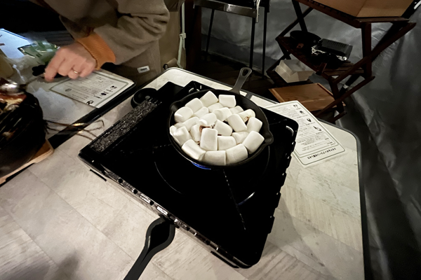 カセットコンロに好きレットを置いてマシュマロを並べてスモアを作る様子
