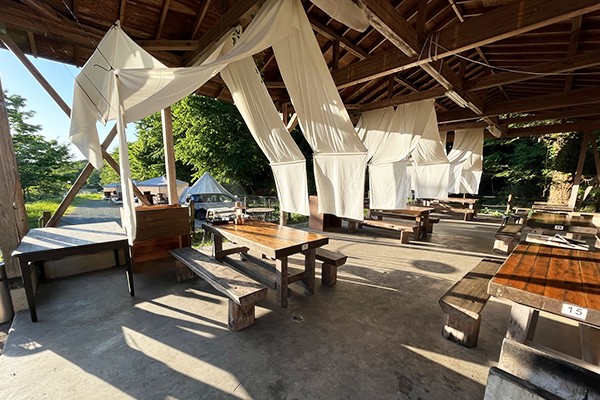 BBQ用の東屋に朝日が差込み、白い布がそよいでいる様子