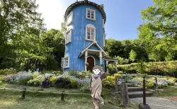 ムーミン屋敷を背景に子供がピースして記念撮影する様子