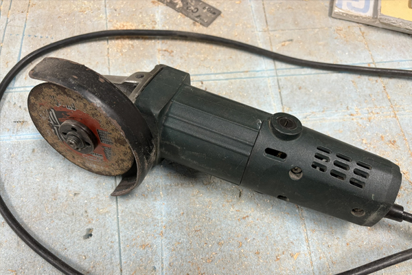 先端に円盤状の砥石が付いた電動工具が置かれている様子