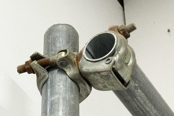 銀色の単管パイプが直角に交わってクランプで留められている写真